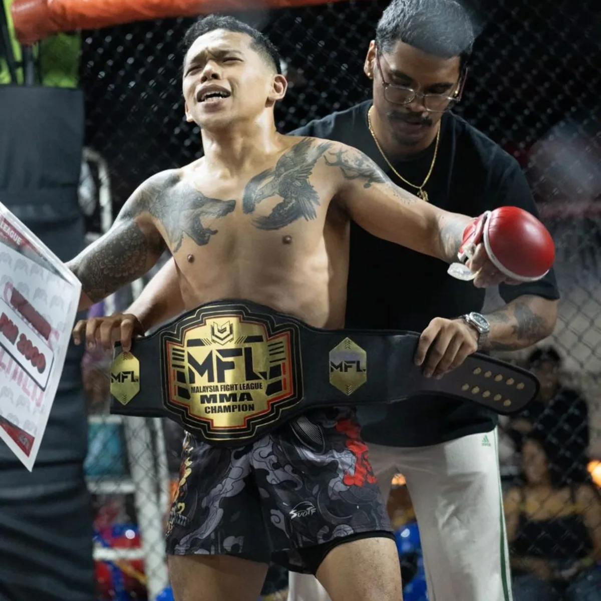 Coach Aiman being strapped with the Malaysia Fight League MMA Champion belt